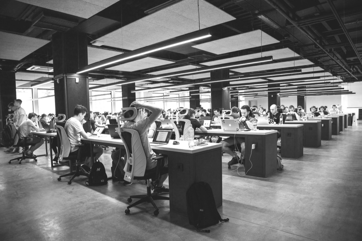 An open office floor with teams working at long desks